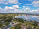 Aerial view of a home with a lake in the background, set against a beautiful cloudy sky at 123 Lakeview Dr, Auburndale, FL 33823