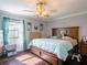This bedroom features dark hardwood floors, a ceiling fan, and lots of natural light at 123 Lakeview Dr, Auburndale, FL 33823