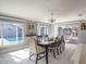 Bright dining room featuring a large window view to the pool, a modern light fixture, and elegant furnishings at 123 Lakeview Dr, Auburndale, FL 33823