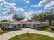 Charming one-story home featuring a circular driveway, lush landscaping, and a well-maintained lawn at 123 Lakeview Dr, Auburndale, FL 33823