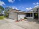 Spacious two-car garage with white door adjacent to the covered patio of this single-story home at 123 Lakeview Dr, Auburndale, FL 33823