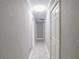 Hallway with white tile flooring, neutral-colored walls, and white doors at 123 Lakeview Dr, Auburndale, FL 33823