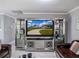 Living room featuring a mirrored entertainment center showcasing a view of the property at 123 Lakeview Dr, Auburndale, FL 33823