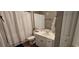 Bright bathroom with a vanity, toilet, shower and white tiled shower and curtain at 14214 Fredricksburg Dr # 106, Orlando, FL 32837