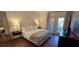 Comfortable main bedroom featuring hardwood floors, a stylish bed, modern nightstands, and private balcony access at 14214 Fredricksburg Dr # 106, Orlando, FL 32837
