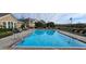 Community pool featuring lounge chairs and adjacent building at 14214 Fredricksburg Dr # 106, Orlando, FL 32837