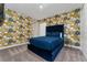 Bedroom with blue velvet bed and Versace-themed wallpaper at 1432 Reunion Blvd, Reunion, FL 34747