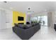 Bright and airy living room with a yellow accent wall, comfortable seating, and marble floors at 1432 Reunion Blvd, Reunion, FL 34747