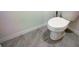 Simple, clean bathroom with white toilet and grey tile floor at 1836 Delrose Rd, Kissimmee, FL 34744