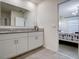 Bathroom with double vanity, granite countertop, and view of bedroom at 1836 Delrose Rd, Kissimmee, FL 34744