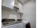 Laundry room with Whirlpool washer and dryer and upper cabinets at 1836 Delrose Rd, Kissimmee, FL 34744