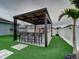 Modern outdoor kitchen with pergola, bar seating, and built-in grill at 1836 Delrose Rd, Kissimmee, FL 34744