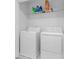 Bright laundry room with washer, dryer, and shelving at 2106 Crystal Bell St, Orlando, FL 32824