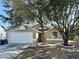 Tan house with white garage door and landscaping at 248 Lindale St, Lakeland, FL 33809