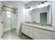 Bathroom features granite double vanity, white cabinets, and a shower with glass door at 2559 Sedge Grass Way, Orlando, FL 32824
