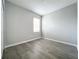 The empty bedroom with gray floors has a window that provides plenty of natural light at 2559 Sedge Grass Way, Orlando, FL 32824