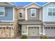 Two-story townhome with light-grey and blue siding, and a two-car garage at 2559 Sedge Grass Way, Orlando, FL 32824