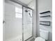 Tiled shower with glass door, rain shower head, and black shelves creates a spa-like bathroom at 2559 Sedge Grass Way, Orlando, FL 32824