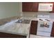Well-lit kitchen featuring stainless steel sink, white appliances and marble style countertops at 261 Autumn Ln # 4, Kissimmee, FL 34743