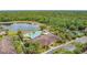 Overhead view of the community clubhouse, pool, and surrounding natural landscape with mature trees at 2833 Oakwater Dr # 169, Kissimmee, FL 34747