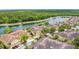 Aerial view of neighborhood townhomes with community pond surrounded by a lush tree line at 2833 Oakwater Dr # 169, Kissimmee, FL 34747