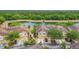 Aerial view of townhomes with tile roofs situated on a pond and surrounded by mature trees at 2833 Oakwater Dr # 169, Kissimmee, FL 34747