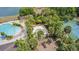 An aerial view of community amenities, including a pool, playground, tennis court, and tropical landscaping at 2833 Oakwater Dr # 169, Kissimmee, FL 34747