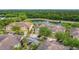 Aerial view of the townhomes with tile roofs overlooking a pond and surrounded by mature landscaping at 2833 Oakwater Dr # 169, Kissimmee, FL 34747