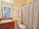 Functional bathroom with a vanity, toilet, and shower with a patterned curtain at 2833 Oakwater Dr # 169, Kissimmee, FL 34747