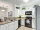 Kitchen features white cabinets, granite countertops, black appliances, and tile flooring at 2833 Oakwater Dr # 169, Kissimmee, FL 34747