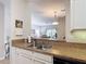 Stainless steel kitchen sink and granite counter with open view to the dining and living areas at 2833 Oakwater Dr # 169, Kissimmee, FL 34747