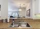 Kitchen sink with granite countertop, stainless steel faucet, and an open view to the dining and living area at 2833 Oakwater Dr # 169, Kissimmee, FL 34747