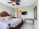 Tranquil main bedroom with a large wooden bed frame, ceiling fan, and a mounted TV at 2833 Oakwater Dr # 169, Kissimmee, FL 34747