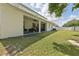 Spacious backyard with a covered patio, lush green lawn, and white fencing for privacy at 3209 Eagle Watch Dr, Kissimmee, FL 34746