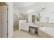Bright bathroom featuring a glass-enclosed shower, vanity area, and a luxurious soaking tub at 3209 Eagle Watch Dr, Kissimmee, FL 34746