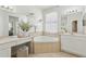 Elegant bathroom boasts a corner soaking tub, vanity, and natural light from the window at 3209 Eagle Watch Dr, Kissimmee, FL 34746