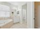 Well-lit bathroom with a corner tub, vanity with sink, and a separate toilet area at 3209 Eagle Watch Dr, Kissimmee, FL 34746