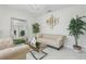 Bright living room with modern decor, including a crystal chandelier and neutral-toned sofa and chairs at 3209 Eagle Watch Dr, Kissimmee, FL 34746