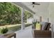 Covered patio with wicker furniture and lush landscaping provides an inviting outdoor space at 3209 Eagle Watch Dr, Kissimmee, FL 34746