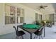 Covered patio boasts a game table, ceiling fan, and comfortable seating area for entertaining at 3209 Eagle Watch Dr, Kissimmee, FL 34746