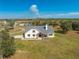 Aerial view of a charming farmhouse on a spacious lot with mature trees at 3449 N Canoe Creek Rd, Kenansville, FL 34739