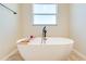 Relaxing bathroom with a freestanding tub and window at 3449 N Canoe Creek Rd, Kenansville, FL 34739