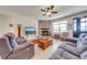 Spacious living room with a cozy stone fireplace and hardwood floors at 3449 N Canoe Creek Rd, Kenansville, FL 34739
