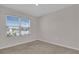 A bright carpeted bedroom has a large window overlooking a sunny landscape at 401 Chayne Pl, St Cloud, FL 34771