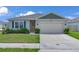Inviting single-story home with a neatly kept lawn, a two-car garage and a welcoming front door at 401 Chayne Pl, St Cloud, FL 34771