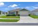 Charming single-story home with a well-manicured lawn and a two-car garage on a sunny day at 401 Chayne Pl, St Cloud, FL 34771