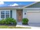 Close-up of home's entrance, showcasing the welcoming front door, sidelight window and well-kept landscaping at 401 Chayne Pl, St Cloud, FL 34771