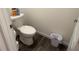 Cozy half bathroom featuring a standard toilet, waste basket and dark wood-look flooring at 401 Chayne Pl, St Cloud, FL 34771