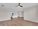 Open-concept living space featuring wood-look floors, a ceiling fan and a modern kitchen in the background at 401 Chayne Pl, St Cloud, FL 34771