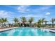 Community pool with lounge chairs, clear blue water, and palm trees under a sunny sky at 401 Chayne Pl, St Cloud, FL 34771